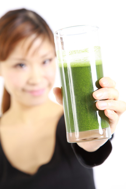 Young Japanese woman with healthy green vegetable juice - Fotó, kép