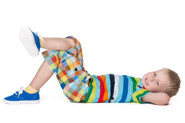 Piccolo ragazzo biondo che riposa sul pavimento
 - Foto, immagini