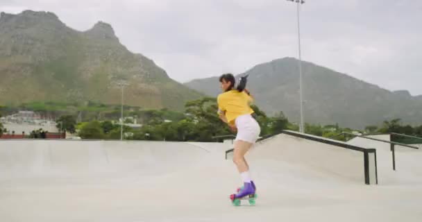 Carefree passionate skater spinning and listening to music on boombox while rollerskating in skate park and rink. One cool young fun woman enjoying free time and dancing while wearing rollerskates. - Footage, Video