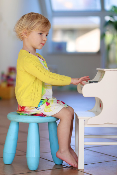 Little girl playing piano toy at home - Φωτογραφία, εικόνα