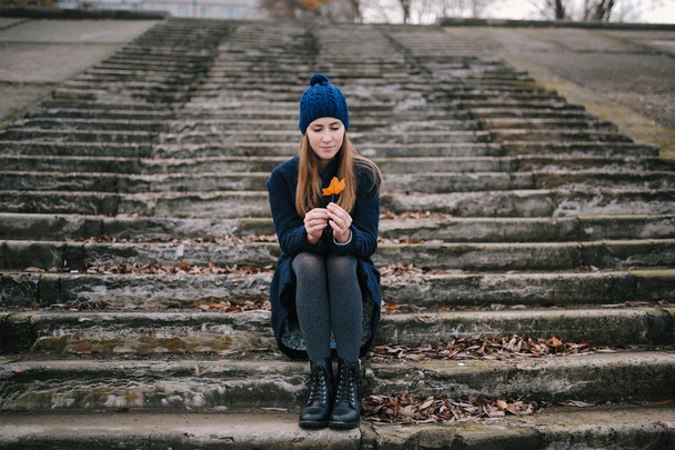the girl in a blue cap sits on steps - Foto, imagen