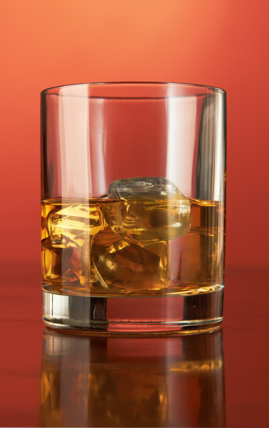 Whiskey with ice cubes on red - Fotoğraf, Görsel