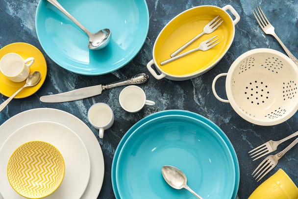 Colorful dinnerware and kitchen utensils on blue background - Photo, Image