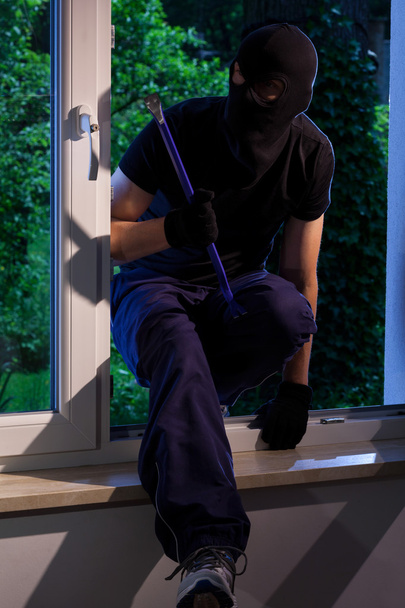 Thief with crowbar in house - Foto, afbeelding