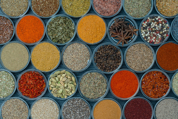 Assortment of aromatic spices, seeds and dry herbs for cooking food on background in small glass bowls, close up, top view - Foto, Imagem