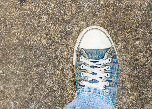 bovenaanzicht oude schoen detail op grunge betonnen vloer - Foto, afbeelding