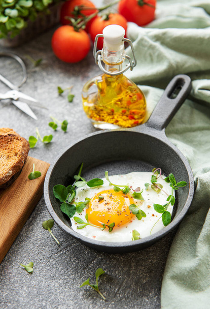 Delicious gourmet Breakfast. Rye bread  with fried egg,  freshly ground pepper and salad with redish and microgreens. Healthy food.  - Foto, afbeelding