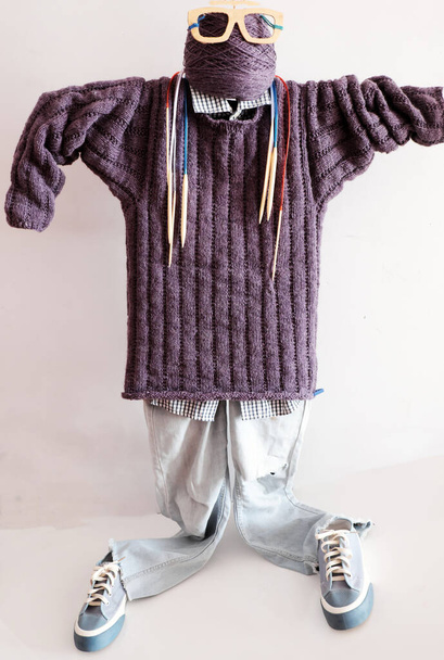 Kézzel készített ajándék apák napjára kötött hobbiból, lila férfi pulóver bábun fa szemüveggel és csoport színes tűkkel fehér háttéren - Fotó, kép