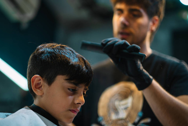 A barber doing a child's haircut - Фото, изображение