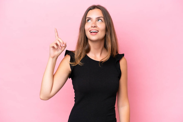 Young caucasian woman isolated on pink background intending to realizes the solution while lifting a finger up - Photo, Image