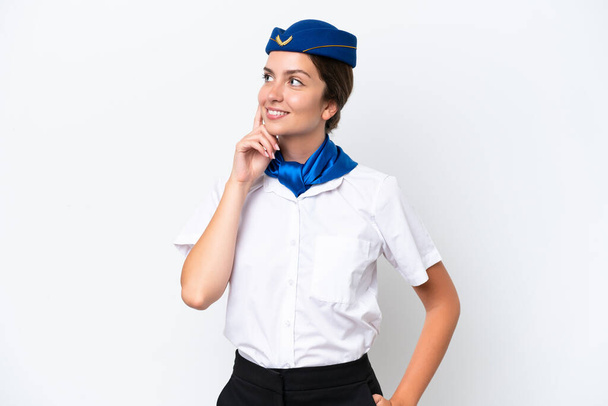 Avion hôtesse femme caucasienne isolé sur fond blanc penser une idée tout en levant les yeux - Photo, image