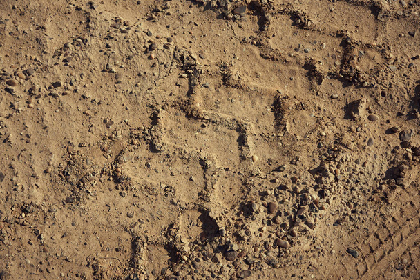 A dirt gravel road with tire tracks texture at the construction site - Foto, imagen