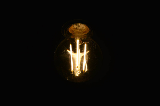 Details of a light bulb in a dark room - Photo, image