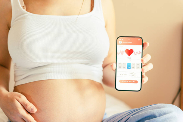 Εφαρμογή ημερολογίου εγκυμοσύνης. Κινητή εγκυμοσύνη σε απευθείας σύνδεση εφαρμογή μητρότητας. Έγκυος μητέρα που χρησιμοποιεί τηλέφωνο. Έννοια της εγκυμοσύνης, μητρότητας, προσδοκία για τη γέννηση του μωρού - Φωτογραφία, εικόνα