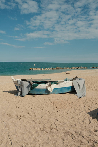 A vertical shot of old wooden boat on sandy beach - Foto, Bild