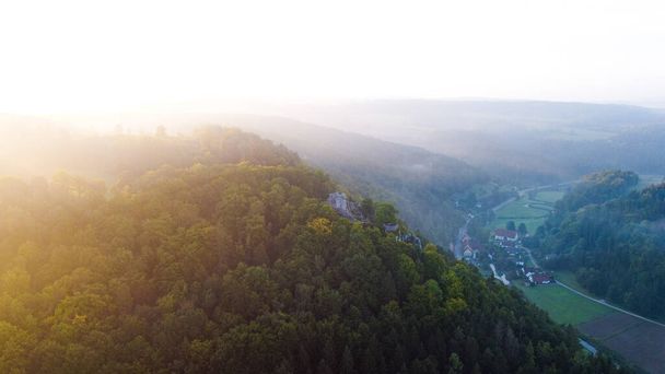 A scenic view of a fog above a village surrounded with greenery - Fotografie, Obrázek