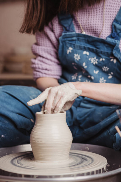 Close-up on woman hands creating handmade ceramic vase in a pottery. Creative workshop. - Фото, изображение