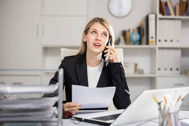 Elegance confident businesswoman sitting in office at workplace talking on phone - Foto, afbeelding