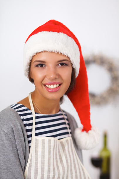 Jovem feliz sorrindo feliz se divertindo com preparações de Natal usando chapéu de Papai Noel - Foto, Imagem