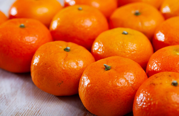 Heap of fresh whole clementines on wooden background. Concept of health benefits of citrus - Foto, Imagem