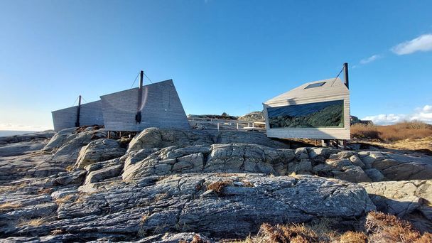 A miniature cabin houses in the south of Norway with large panoramic windows and stand on mounts that are drilled into the rock. - Фото, зображення