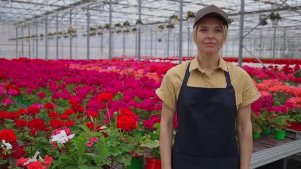 Mulher florista em estufa mostrando tabuleta desculpe estamos fechados - Filmagem, Vídeo