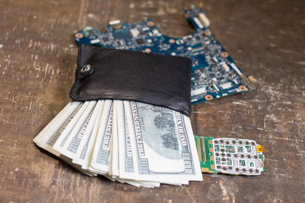 Гаманець з банкнотами на материнських платах. Підвищення цін на електроніку у зв "язку з війною в Україні - Фото, зображення