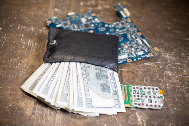Borsa con banconote sulle schede madri. L'aumento dei prezzi dell'elettronica in relazione alla guerra in Ucraina - Foto, immagini