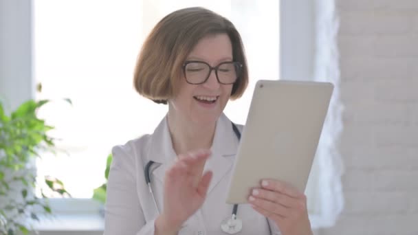 Портрет видеовызова на планшете от врача-женщины в офисе  - Кадры, видео