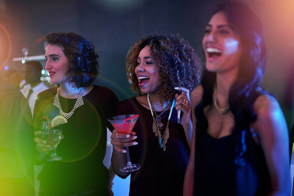 Foto de un grupo de amigos disfrutando en un club nocturno. - Foto, Imagen