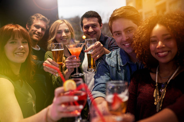 Portrét skupiny lidí připíjejících si se svými nápoji v nočním klubu. - Fotografie, Obrázek