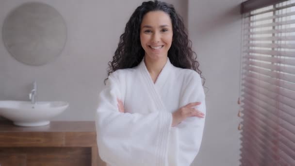 Fiatal vonzó spanyol nő álló kopott fürdőköpeny magabiztos női modell pózol keresztbe karok spa szalonban boldog lány elégedett kozmetikai eljárás élvezze frissesség tiszta test - Felvétel, videó