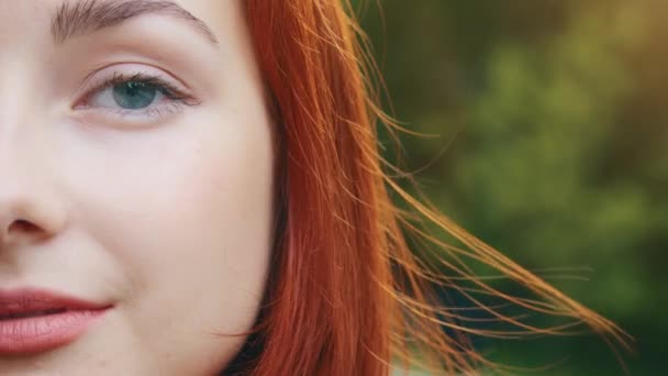 Nahaufnahme menschliches weibliches Halbgesicht hübscher Teenager schöne rothaarige Mädchen Frau Sinnlichkeit Modell mit schönen blauen Augen Naturkosmetik Make-up hat perfekte saubere Haut posiert für Kamera steht im Freien - Filmmaterial, Video