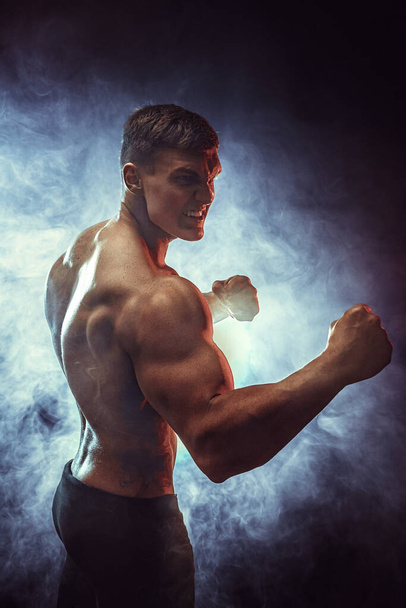 Sportman bokser vecht met zijn schaduw op zwarte achtergrond. Begrepen Ruimte. Boksen sport concept. Rook op achtergrond.  - Foto, afbeelding