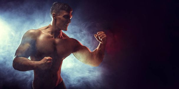 Sportsman boxer fighting with his shadow on black background. Copy Space. Boxing sport concept. Smoke on background.  - Φωτογραφία, εικόνα