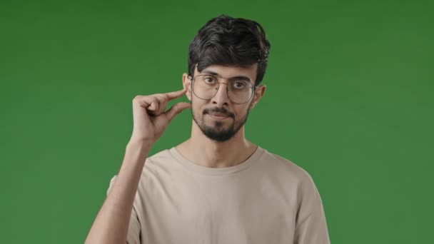 Tyytymätön arabi mies pettynyt latino brunette kaveri eristetty seisoo vihreä studio tehdä pieni muoto ele sormet osoittavat pieni mitta koko pieni mittakaavassa alhainen luokitus pyytää vähemmän pala - Materiaali, video