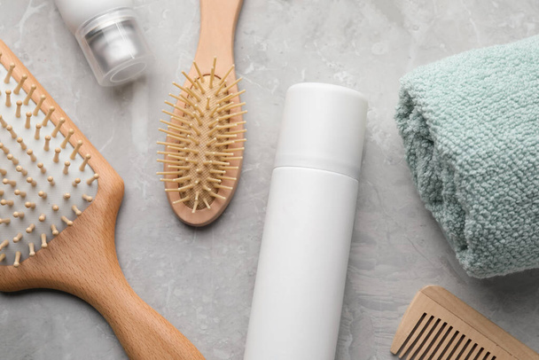 Dry shampoo sprays, towel and hairbrushes on light grey table, flat lay - Fotoğraf, Görsel