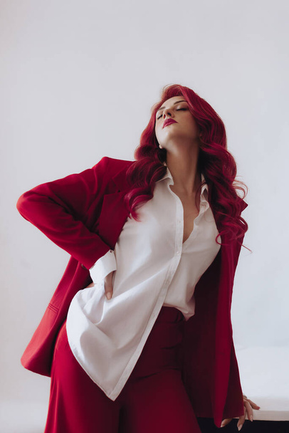 Ukraińska młoda dziewczyna w czerwonym garniturze na jasnym tle. Kobiece ciało i koncepcja stylu. Projekt reklamy lub sprzedaży odzieży. - Zdjęcie, obraz