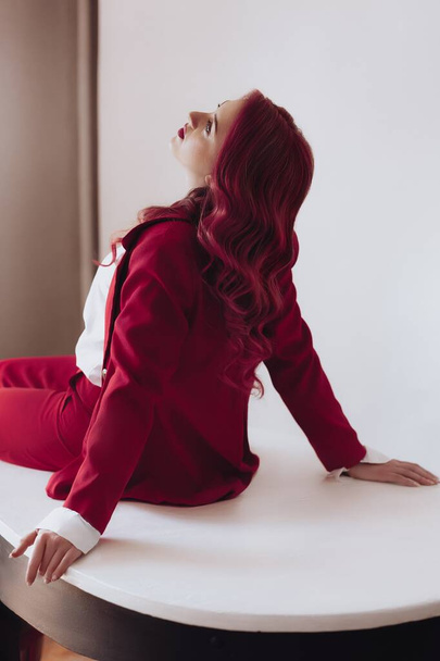 Ragazza ucraina in un abito rosso su sfondo chiaro. Corpo femminile e concetto di stile. Pubblicità o vendita di vestiti di design. - Foto, immagini