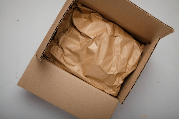 Doğal kağıt paketi, beyaz arka planda bir karton. Çevre dostu, plastik ürün ambalajı yok. Çevreye özen, ekolojiye dikkat - Fotoğraf, Görsel