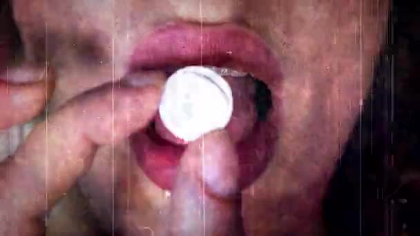 Una mano poniendo una píldora en una lengua femenina - Imágenes, Vídeo