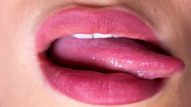 Uma mulher lambendo seus lábios vermelhos completos com a língua  - Filmagem, Vídeo