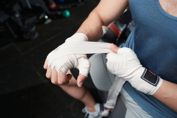 Cropped photo of professional sportsman wrapping elastic bandage around his right hand - Foto, Bild