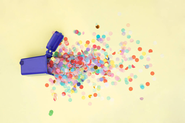 Trash bin and confetti on pastel light yellow background. Creative party composition. Minimal fun garbage concept. - Foto, Imagem