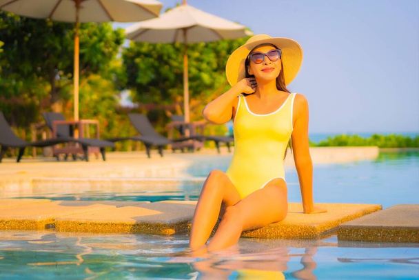 Retrato hermosa joven asiática mujer relajarse sonrisa disfrutar de ocio alrededor de la piscina en resort hotel de vacaciones - Foto, Imagen