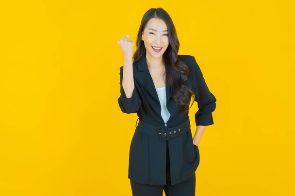 Portret mooie jonge aziatische vrouw glimlach met actie op kleur achtergrond - Foto, afbeelding