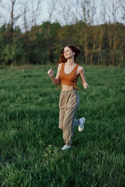 Una mujer atlética corre y entrena su cuerpo antes de la temporada de verano en el parque. Foto de alta calidad - Foto, Imagen