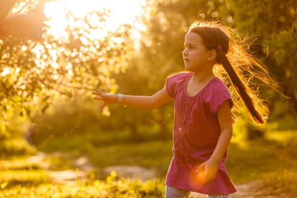 Cinco años de edad niña caucásica soplando burbujas de jabón al aire libre al atardecer - feliz infancia despreocupada
 - Foto, imagen