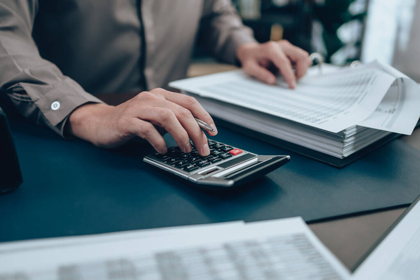Investors working on desk office and using a calculator to calculate balance, profit, currency and cost. Accounting and  Financial concept. - Foto, imagen