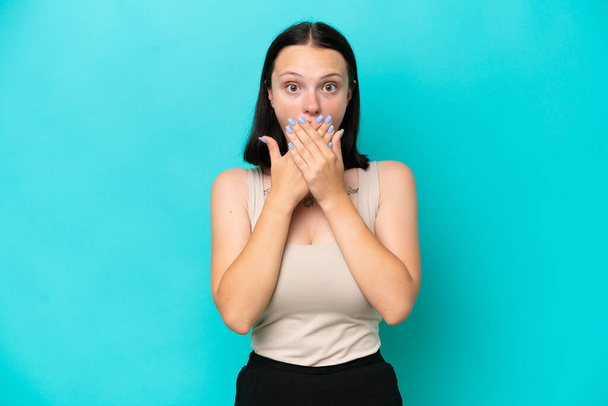 Mladá běloška žena izolované na modrém pozadí pokrývající ústa s rukama - Fotografie, Obrázek